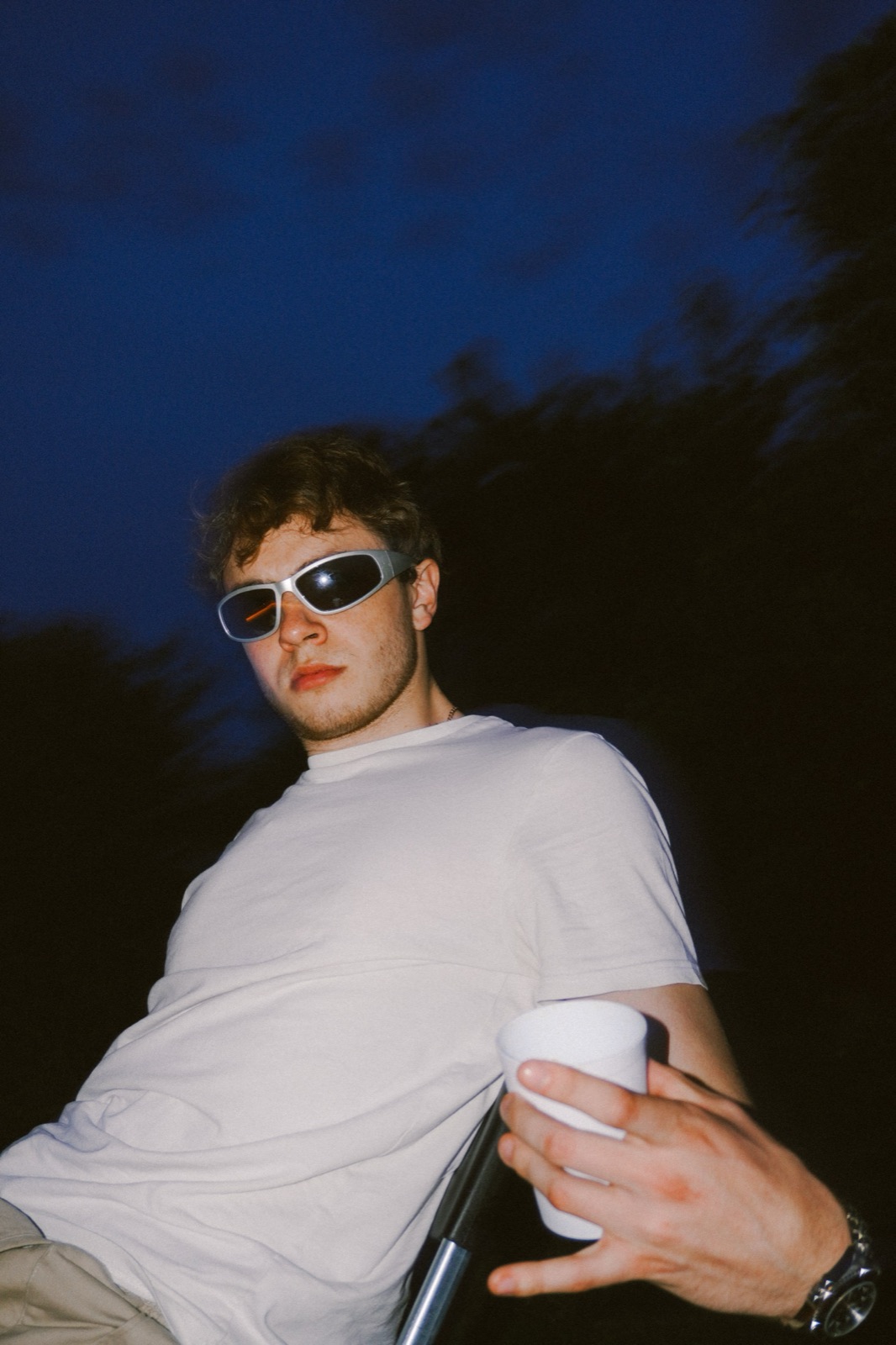 Portrait of a man in white sunglasses outdoors at blue hour