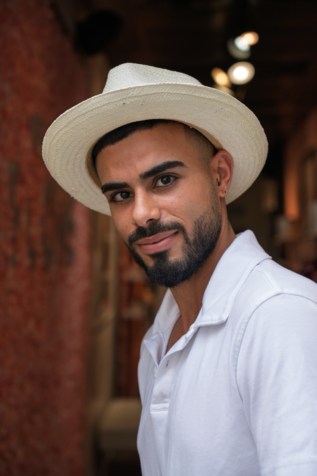 Portrait of a man in a straw hat and white polo shirt