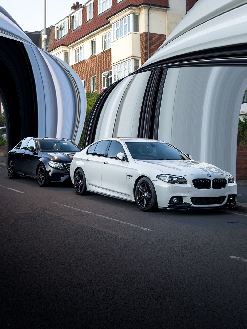 White BMW and black Mercedes parked on a London street at golden hour